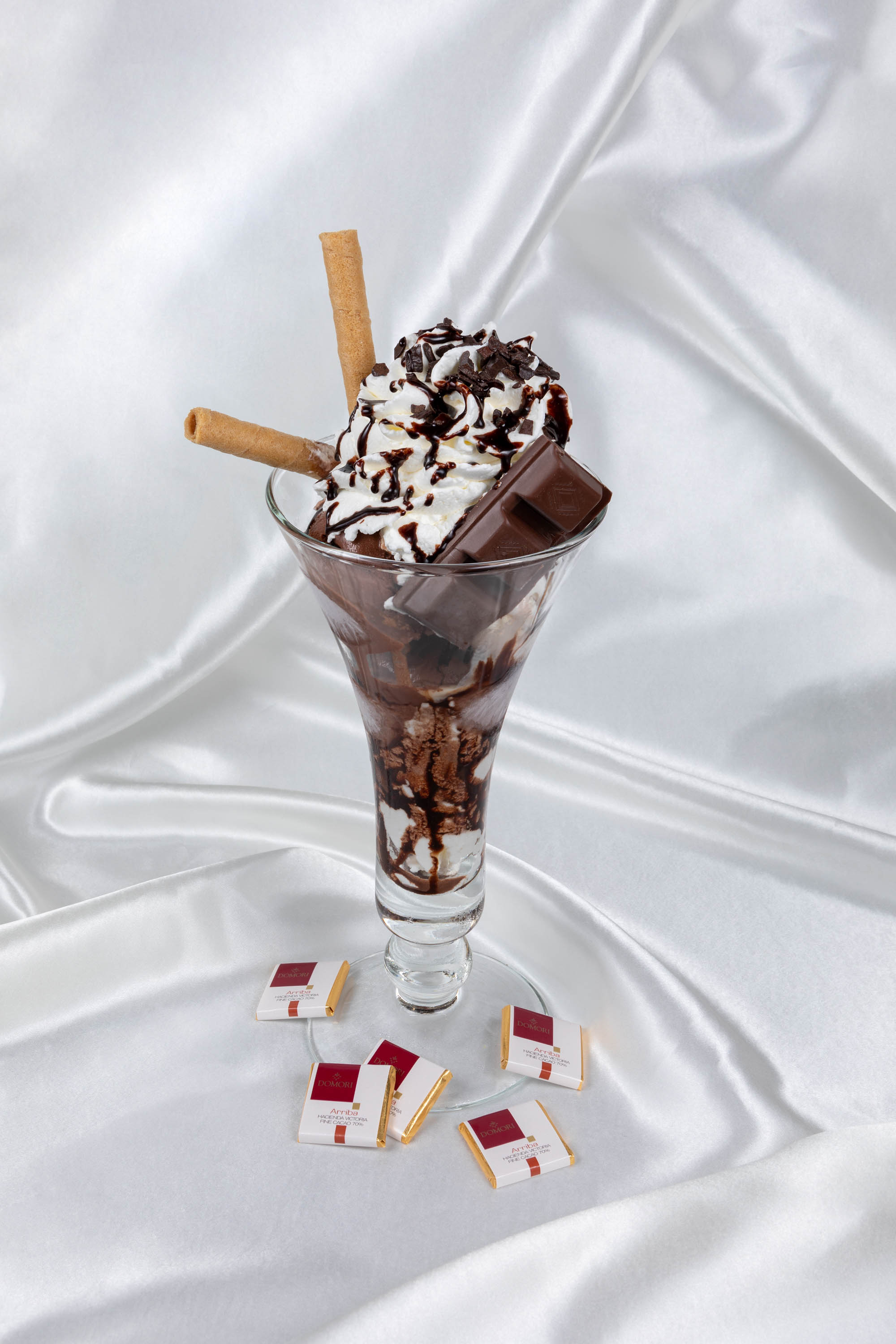 foto di una coppa gelato alla cioccolata con drappo in seta bianca sullo sfondo
