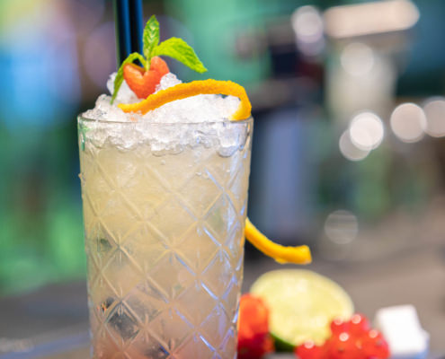 Fotografo cocktail con sfondo sfocato analcolico alla frutta sul bancone del bar