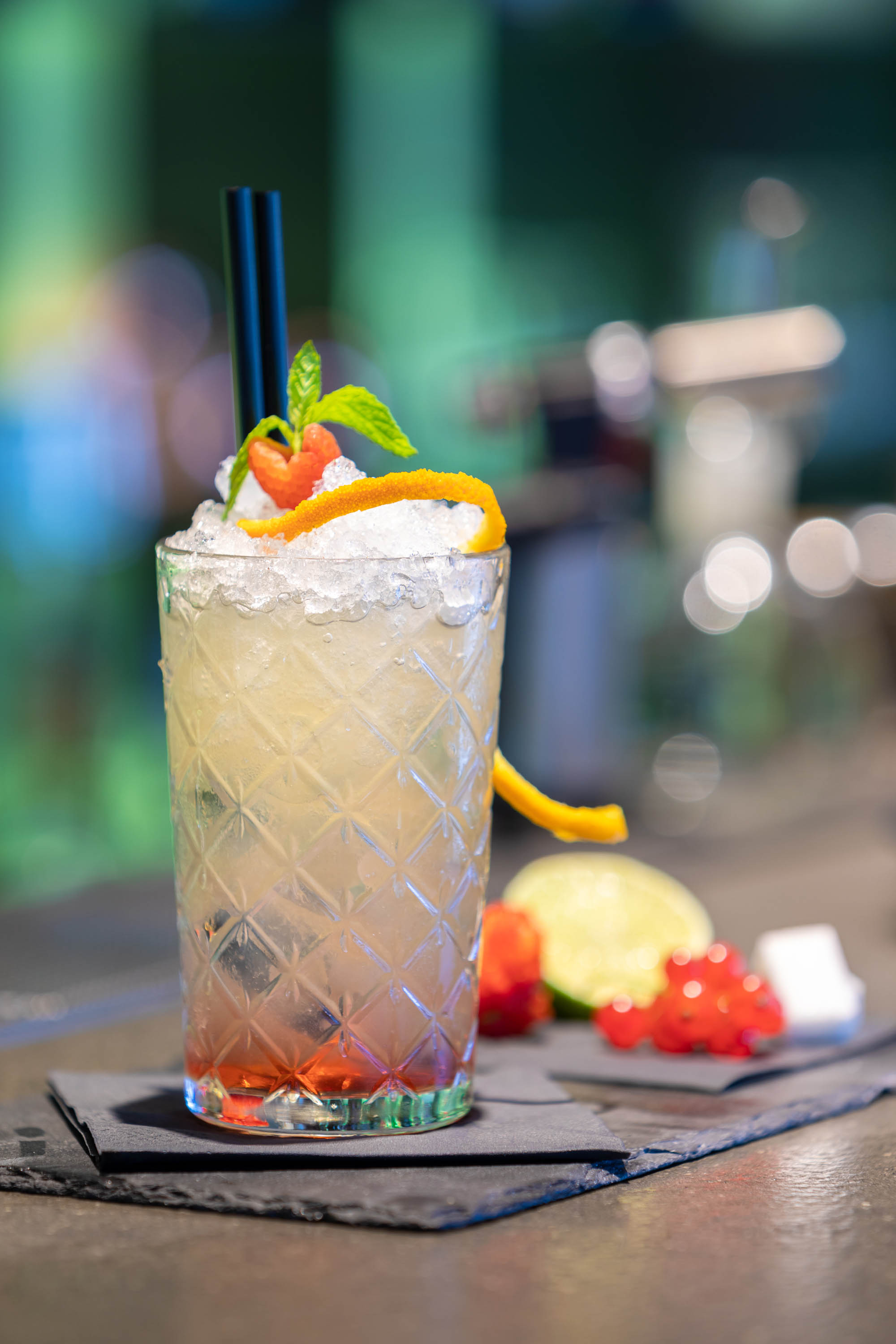 Fotografo cocktail con sfondo sfocato analcolico alla frutta sul bancone del bar
