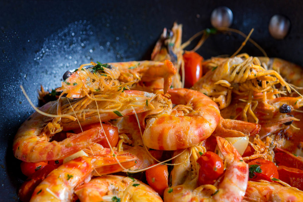 Fotografo food cucina padella di gamberi saltati in padella coi pomodori