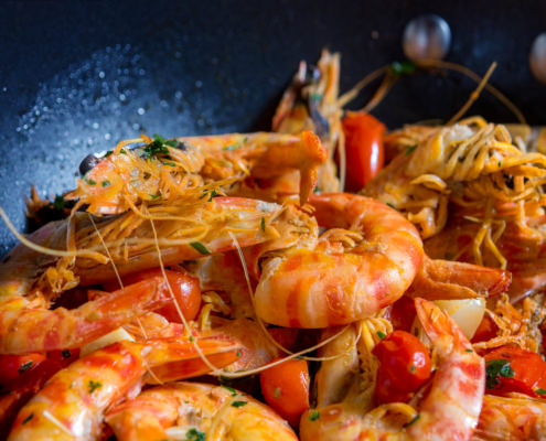 Fotografo food cucina padella di gamberi saltati in padella coi pomodori