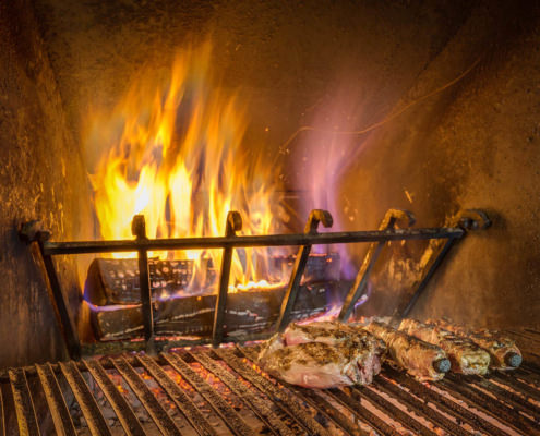 Fotografo Ristorante foto caminetto acceso con carne alla brace