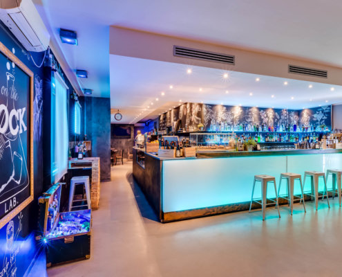 Servizi fotografici ristoranti foto ingresso bar serale illuminato a led con lavagna e luci blu viola verdi