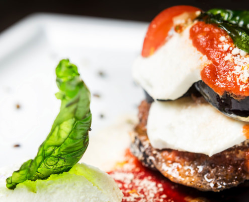 servizio fotografico a piatto di parmigiana di melanzane tricolore